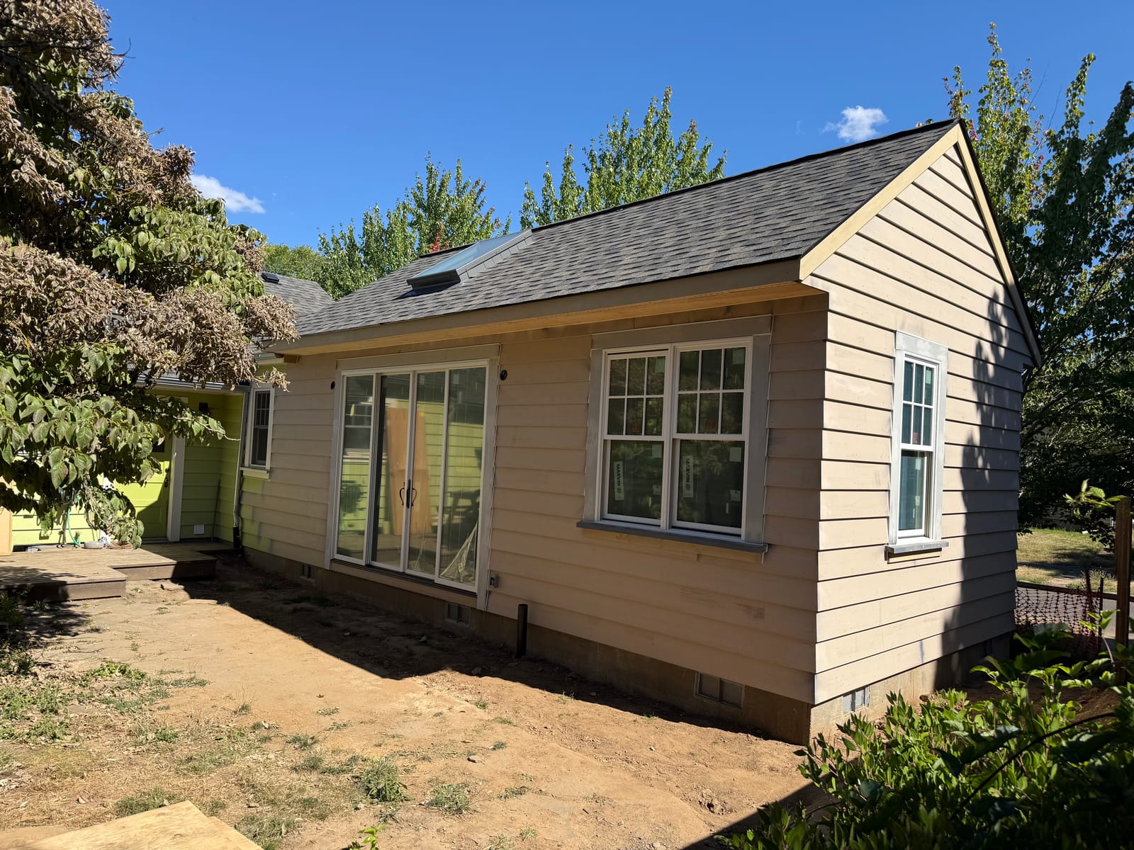Finished detached backyard ADU in Concordia, NE Portland with lap siding, skylights, and sliding glass doors — built by K&H Construction