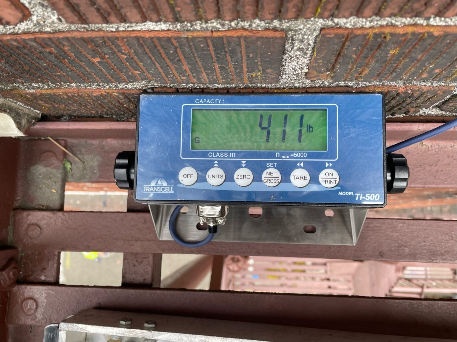 Calibrated load cell readout showing 411 pounds during a fire escape load test in Portland